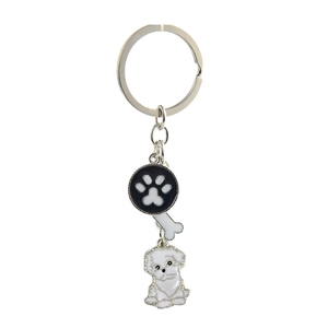 Detail view of Bichon dog keychain with bone and paw print charms in silver metal