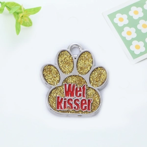 Detail of glitter paw pet ID tag with Wet Kisser text in polished silver metal frame