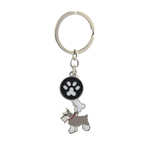 Detail of metal pet keychain with black paw print charm, white bone and Schnauzer pendant