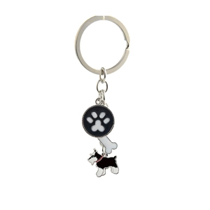 Detail view of metal pet keychain with paw print, bone charm, and Schnauzer dog pendant