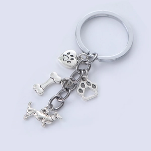 Porte-clés chien minimaliste avec charms teckel, os et pattes sur fond blanc épuré