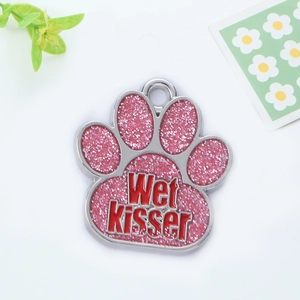 Detail of pink glitter paw-shaped pet ID tag with Wet Kisser engraved text