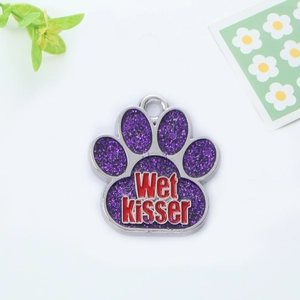 Detail of purple glitter paw-shaped pet ID tag with Wet Kisser letter engraving