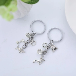 Porte-clés chien en métal argenté avec pendentifs en forme d'os, de patte et de teckel