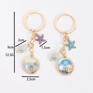 Golden dolphin and whale keychain set with starfish charms and marine terrarium pendant