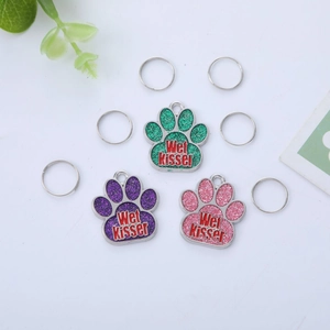 Glitter paw-shaped pet ID tags with Wet Kisser text in green, purple, and pink colors