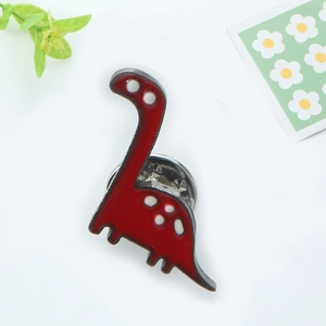 Détail de la broche dinosaure en émail rouge à pois blancs et fermoir papillon argenté