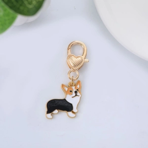 Gros plan d'un pendentif Corgi en émail avec un fermoir mousqueton doré orné d'un cœur