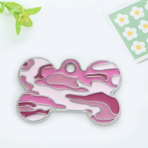Pink camouflage bone-shaped pet dog tag in polished silver frame on fresh floral background