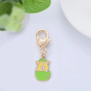 Macro d'un porte-clés corgi en métal avec fermoir mousqueton cœur doré et chapeau vert