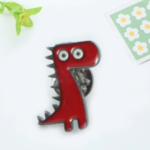 Détail d'un pin's dinosaure rouge mignon avec fermeture papillon sur fond blanc