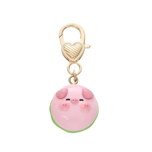 Porte-clés cochon rose en résine avec fermoir doré en forme de cœur sur fond blanc
