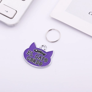 Detail of purple cat-shaped pet tag with fishbone pattern and El Gato Gordo text