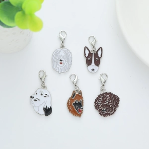 Detail view of five assorted metal dog breed charms with silver lobster clasps for keyrings