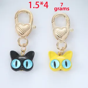Detailed view of yellow and black cat charms with golden heart clasps and dimensions