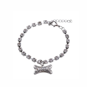 Detail of silver pet collar with shiny rhinestones and a bone shaped crystal pendant