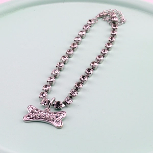 Close-up of sparkling rhinestone pet collar with silver bone pendant and lobster clasp