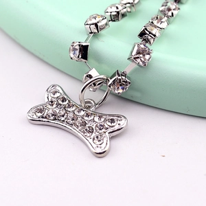 Macro shot of a silver pet necklace with a sparkling crystal bone pendant and rhinestone link