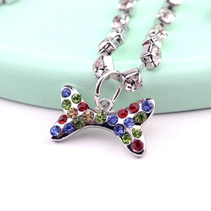 Macro detail of silver pet necklace with colorful crystal bone pendant and rhinestone chain