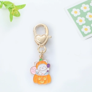 Detail of cute enamel Halloween cat pendant with pumpkin hat and gold heart clasp