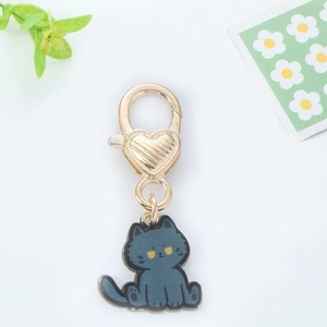 Detail of cute grey enamel cat keychain with golden heart-shaped metal hook closure
