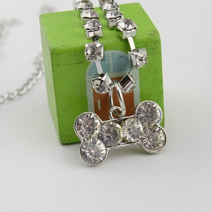 Detail of a sparkling bone-shaped pendant with crystals on a matching iced-out tennis chain