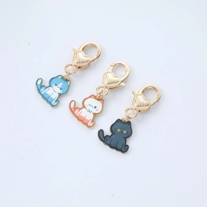 Detailed view of three cute cartoon enamel cat charms with golden heart lobster clasps