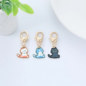 Detailed view of cat metal charms with colorful enamel finish and gold heart lobster clasps
