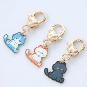 Three cute cartoon cat keychains in blue, pink, and grey with heart lobster clasps