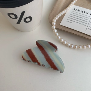Detail of vintage blue and brown checkered hair claw clip with glossy acetate texture