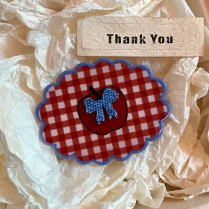 Close-up of vintage red plaid hair claw with apple motif and blue checkered bow detail