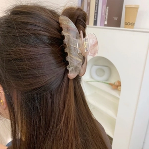 Detail einer glitzernden Schmetterlings-Haarklammer mit Marmor-Muster im Haar