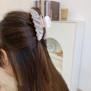 Detail einer eleganten Haarklammer mit Marmormuster bei einer Halff-up-Frisur
