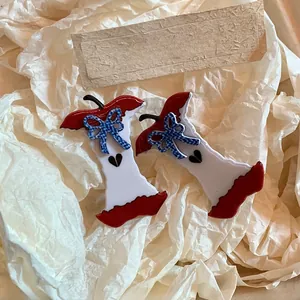 Close-up of apple core hair clips with blue floral bows and heart detail on gift wrap