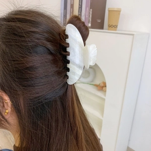 Detailaufnahme der Haarklammer mit Marmormuster in einer Hochsteckfrisur aus hochwertigem PVC