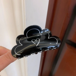 Détail du motif de cœur et de la forme de nuage sur la pince à cheveux noire