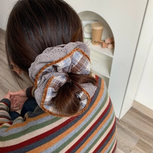 Detailed close-up of brown plaid scrunchie with purple lace and velvet trim details