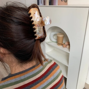 Macro view of high-quality tortoise acetate hair claw clip holding hair in elegant half-up style