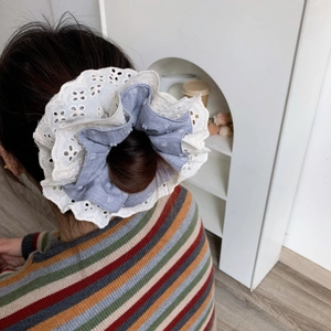 Elegant four-layer lace scrunchie with blue polka dot fabric shown on tied hair