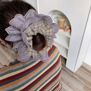 Elegant large layered lace floral scrunchie hair accessory worn on a stylish low bun