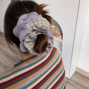 Detailed view of large layered purple lace and brown checkered cotton scrunchie on hair