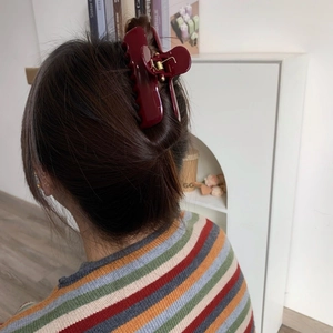 Burgundy acetate teddy bear hair claw clip shown in a natural half-up hair styling