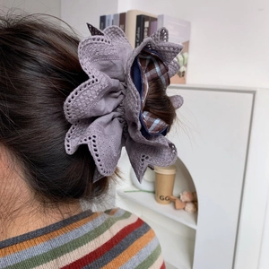 Detail view of lavender lace and brown plaid fabric textures on the layered scrunchie