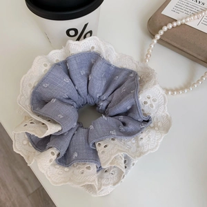 Detailed macro view of blue and white layered fabric scrunchie with lace edge texture