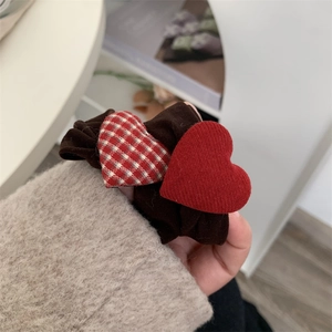 Close-up of a brown scrunchie featuring red and checkered heart charms for girls