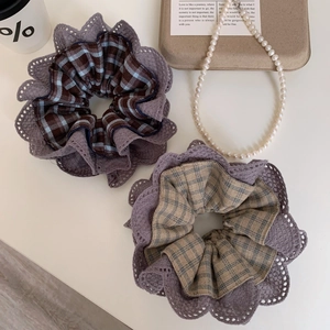 Detailed view of large retro plaid scrunchies featuring elegant purple lace trim edges