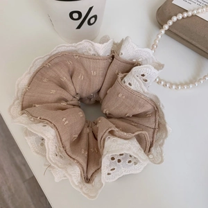 Detail of multi-layered lace hair scrunchie with beige polka dot fabric and coffee cup decor
