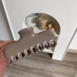 Close-up of a large brown acetate hair claw clip with a glossy finish for hair styling