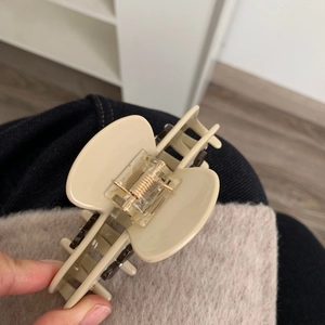 Vista dettagliata di una pinza per capelli in acetato beige con molla robusta e bordi lisci
