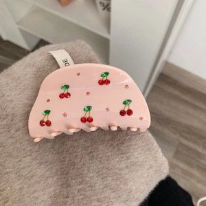 Pince à cheveux cerise rose avec strass rouges et verts sur tissu peluche beige